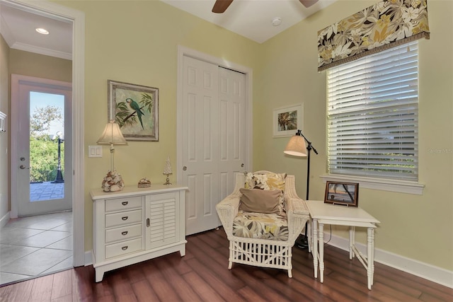 sitting room featuring dark hardwood / wood-style flooring, ornamental molding, and ceiling fan