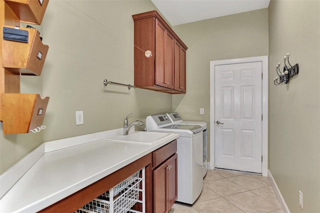 clothes washing area featuring cabinets, sink, washer and dryer, and light tile patterned floors