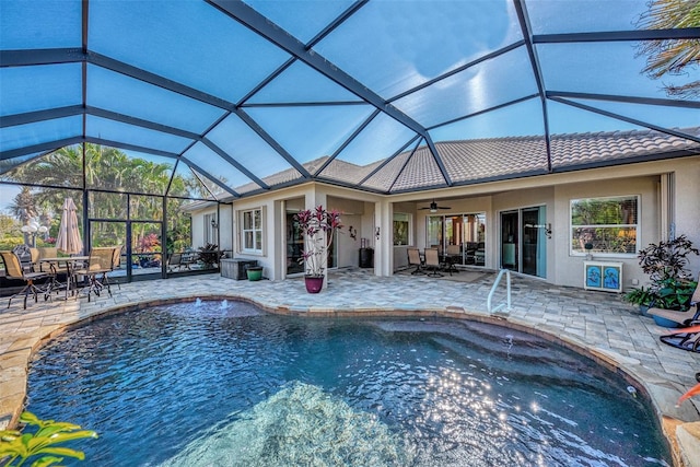 view of pool featuring ceiling fan, glass enclosure, and a patio area