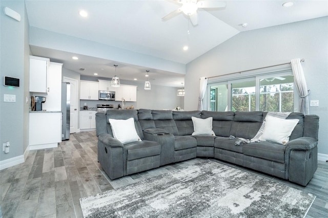 living room with vaulted ceiling, ceiling fan, and light hardwood / wood-style flooring