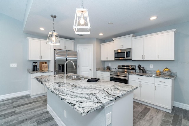 152 Apollo Dr, Rotonda West, FL 33947 - kitchen with stainless steel appliances, a sink, baseboards, pendant lighting, and white cabinets