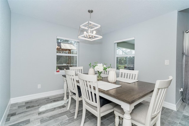 dining space with hardwood / wood-style floors and a notable chandelier