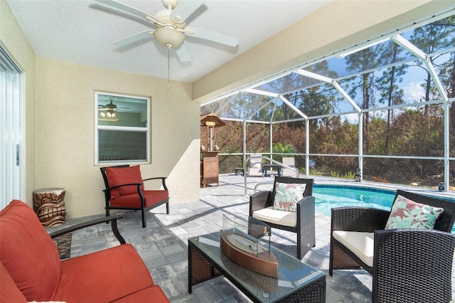 view of patio with ceiling fan, outdoor lounge area, and glass enclosure