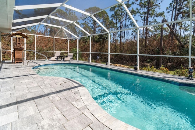 view of swimming pool featuring glass enclosure and a patio