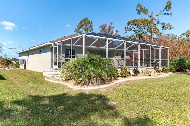 back of property featuring a lawn and a lanai