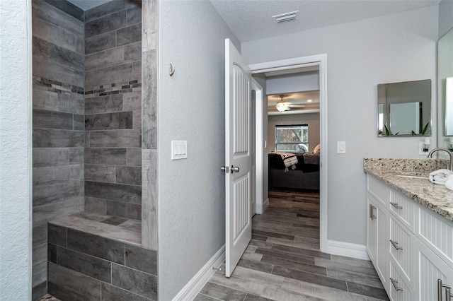 152 Apollo Dr, Rotonda West, FL 33947 - bathroom with wood finished floors, vanity, connected bathroom, a textured wall, and baseboards