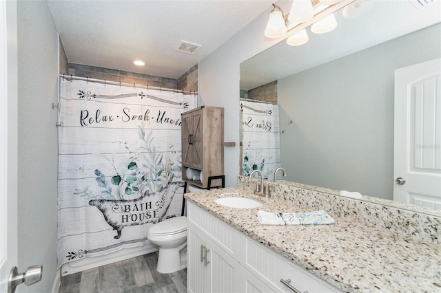 bathroom featuring toilet, vanity, and hardwood / wood-style flooring