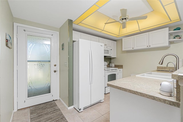 kitchen with white appliances, sink, ceiling fan, light tile patterned floors, and white cabinetry