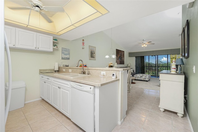 kitchen with lofted ceiling, white appliances, white cabinets, sink, and kitchen peninsula