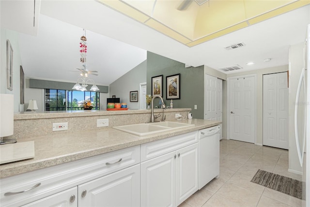 kitchen with white appliances, sink, light tile patterned floors, white cabinetry, and lofted ceiling