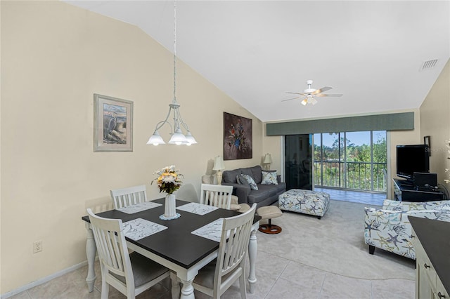 tiled dining space featuring ceiling fan with notable chandelier and high vaulted ceiling