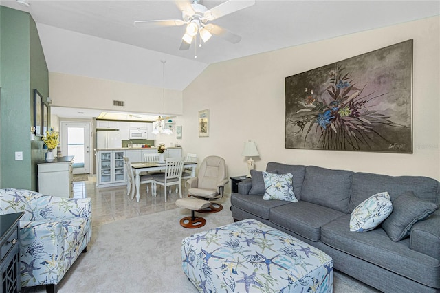 living room featuring ceiling fan, lofted ceiling, and light carpet