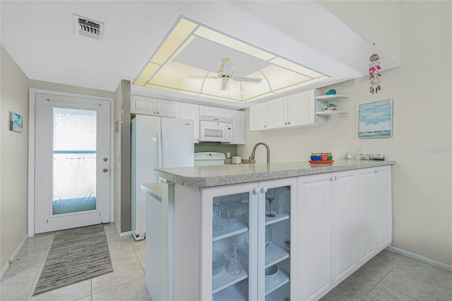 kitchen with white appliances, white cabinets, ceiling fan, light tile patterned floors, and kitchen peninsula