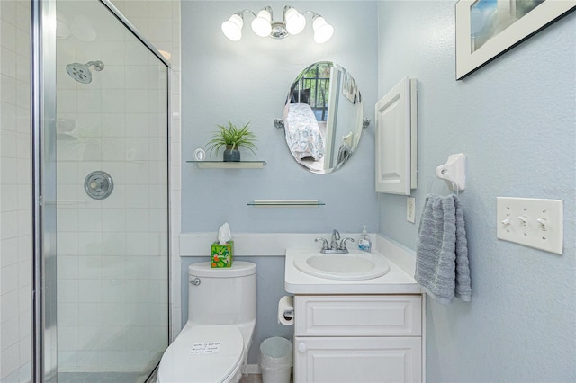 bathroom with vanity, toilet, and a shower with door