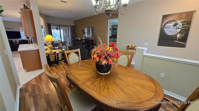 dining area featuring light hardwood / wood-style floors and a notable chandelier