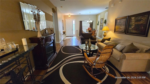 living room with wood-type flooring and a chandelier