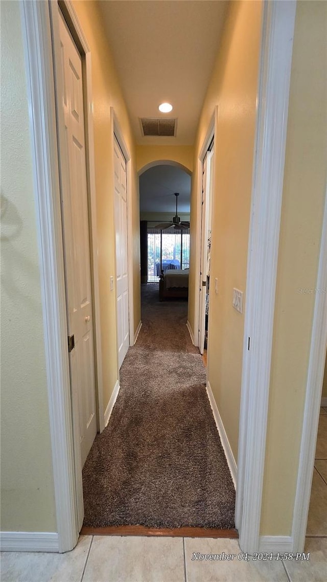 hallway featuring light colored carpet