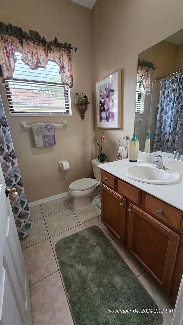 bathroom featuring toilet, vanity, tile patterned floors, and curtained shower