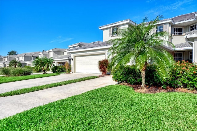 view of front of property featuring a front yard and a garage