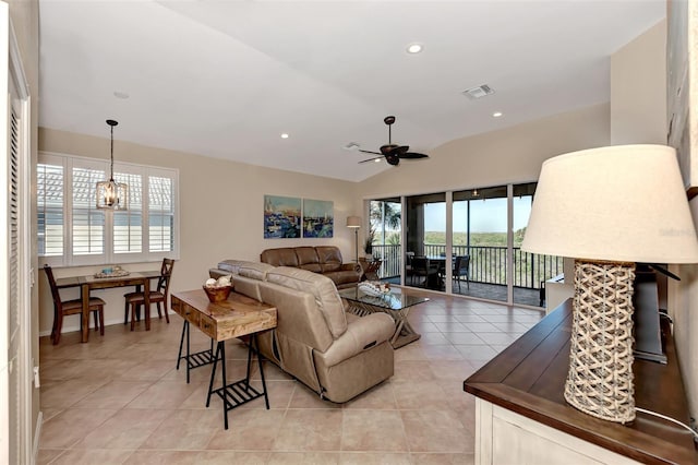 living room featuring light tile patterned flooring, ceiling fan with notable chandelier, and lofted ceiling