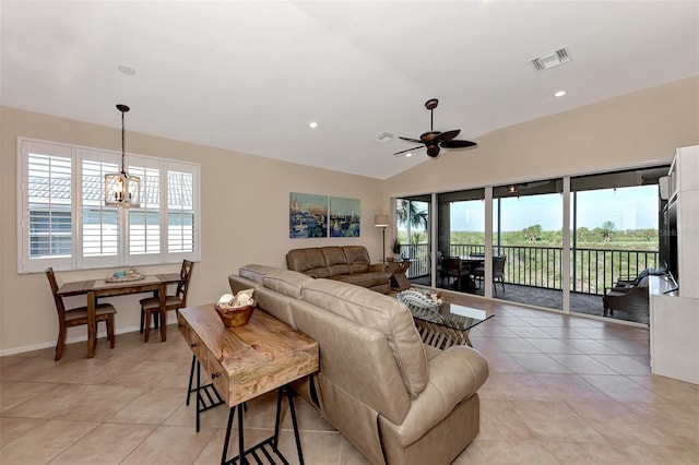 tiled living room featuring lofted ceiling and ceiling fan with notable chandelier