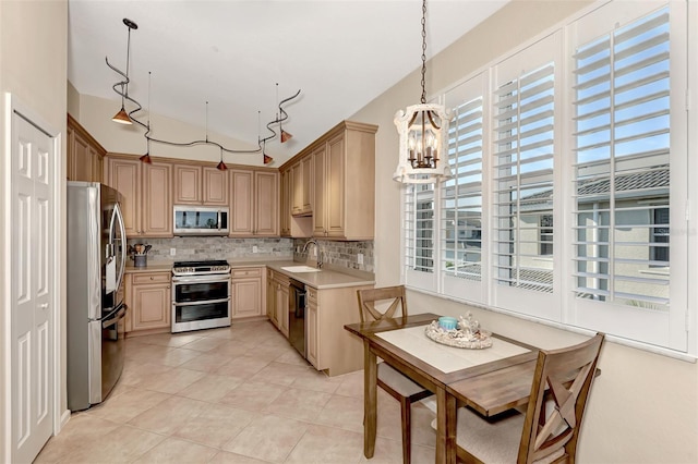 kitchen featuring appliances with stainless steel finishes, tasteful backsplash, light brown cabinets, an inviting chandelier, and pendant lighting