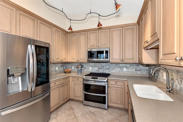 kitchen featuring backsplash, appliances with stainless steel finishes, light tile patterned floors, light brown cabinetry, and sink