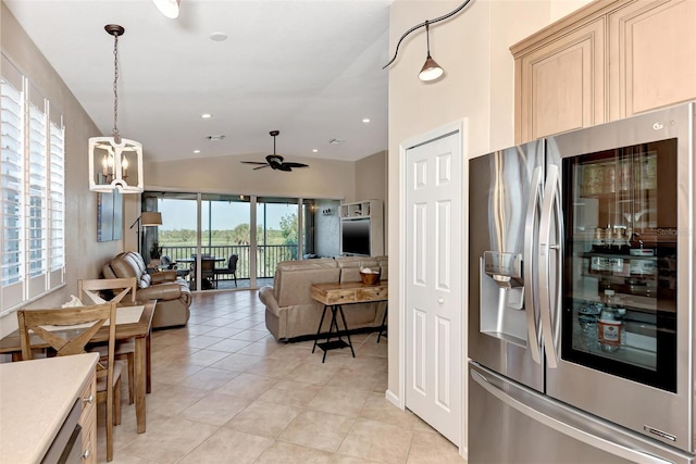 kitchen featuring ceiling fan with notable chandelier, light tile patterned floors, hanging light fixtures, stainless steel fridge with ice dispenser, and vaulted ceiling