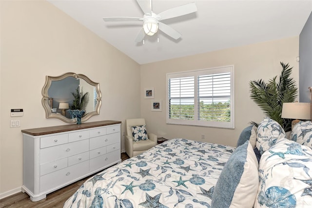 bedroom featuring dark wood-type flooring, vaulted ceiling, and ceiling fan