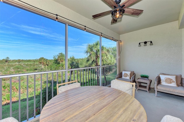 sunroom / solarium featuring ceiling fan