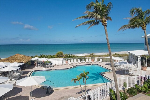 view of swimming pool with a water view and a patio area