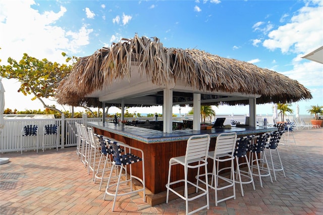 view of patio with a gazebo, a water view, and a bar