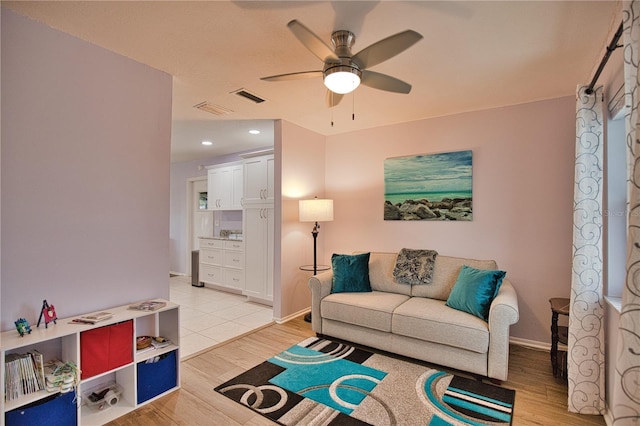 living room with light hardwood / wood-style flooring and ceiling fan