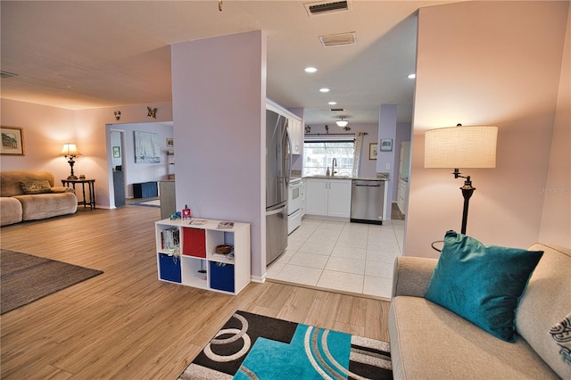 living room with light hardwood / wood-style flooring and sink