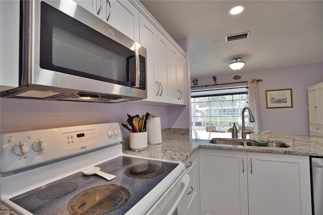 kitchen featuring white cabinets, light stone countertops, sink, and appliances with stainless steel finishes