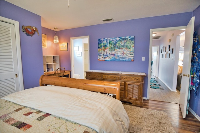 bedroom featuring dark hardwood / wood-style floors, a closet, and ensuite bathroom