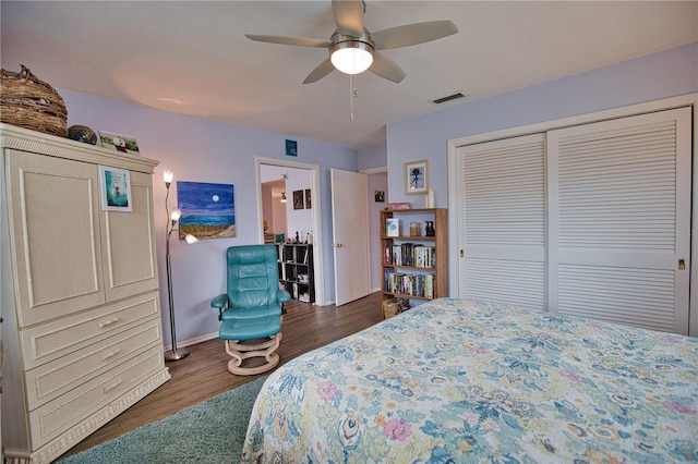 bedroom with ceiling fan, dark hardwood / wood-style floors, and a closet