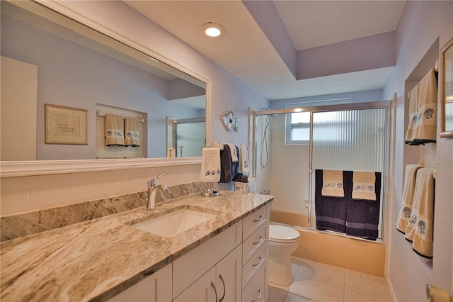 full bathroom with backsplash, tile patterned floors, toilet, shower / bath combination with glass door, and vanity