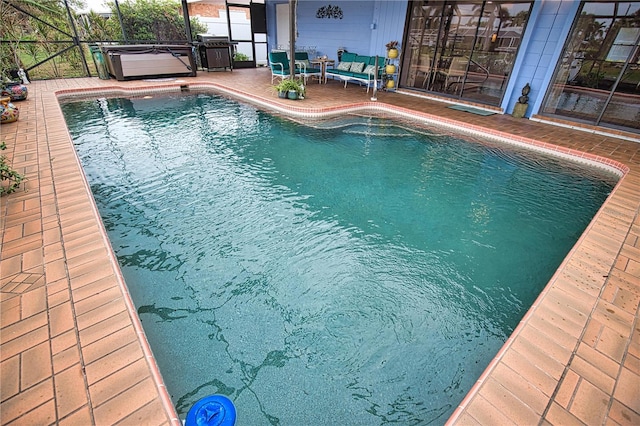 view of pool with a patio and a hot tub