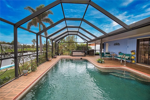 view of swimming pool featuring a lanai, a patio area, a water view, and a hot tub