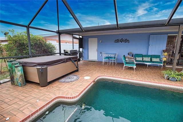 view of pool with glass enclosure, area for grilling, a patio area, and a hot tub