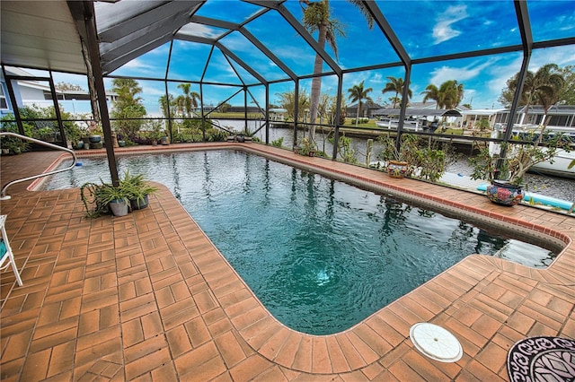 view of pool with a patio, a water view, and a lanai