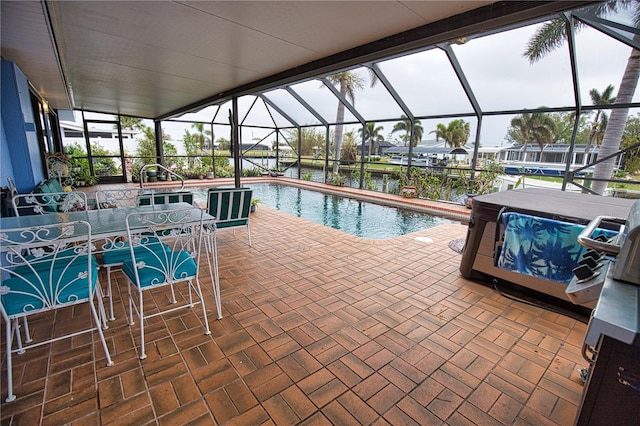 view of swimming pool featuring a patio, a water view, and a lanai