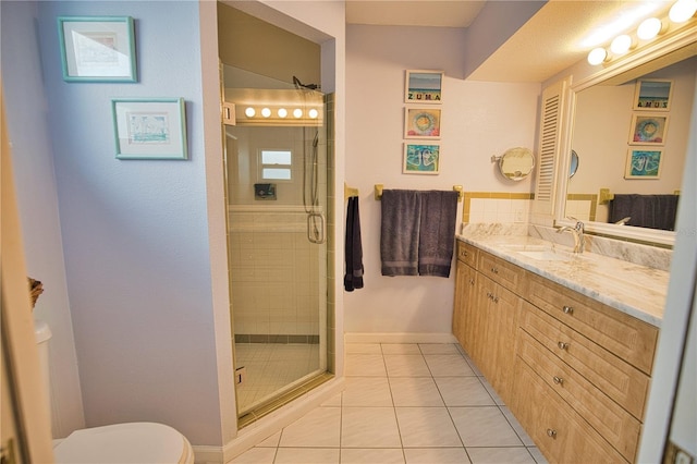 bathroom featuring tile patterned floors, vanity, a shower with shower door, and toilet