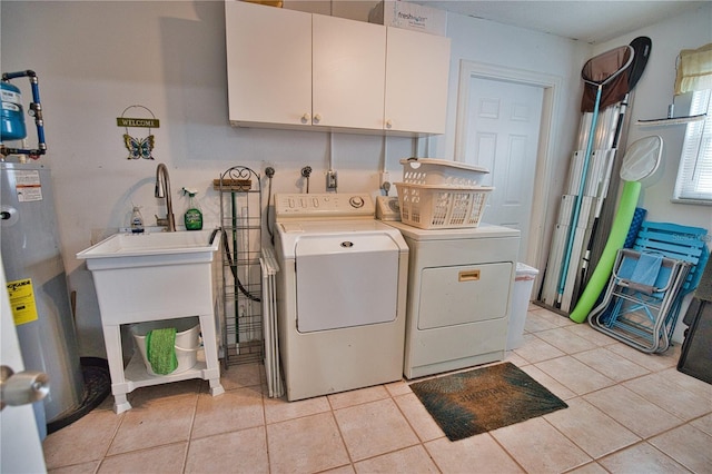 laundry area with washer and dryer, cabinets, light tile patterned floors, and water heater