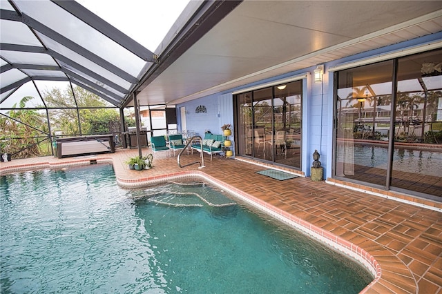 view of pool with a patio, glass enclosure, and a hot tub