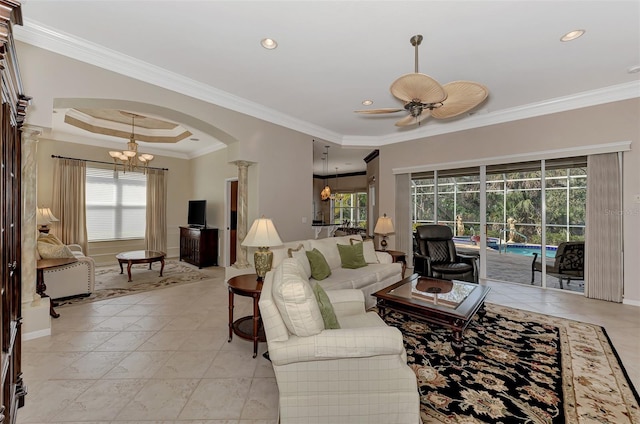 living room featuring decorative columns, ceiling fan with notable chandelier, and crown molding