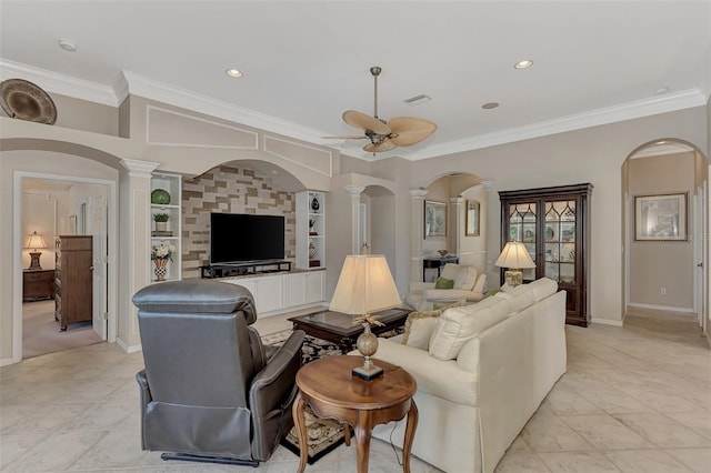 living room with decorative columns, ceiling fan, and ornamental molding