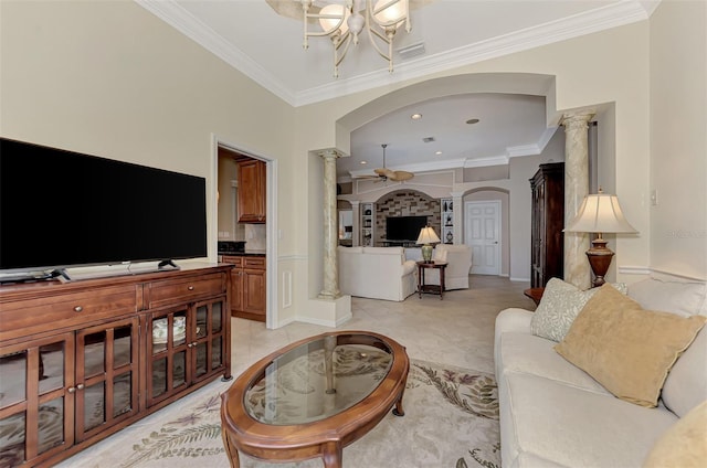 tiled living room with ceiling fan with notable chandelier, ornate columns, and crown molding