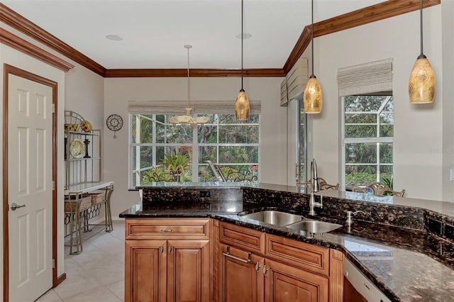 kitchen featuring dark stone countertops, sink, decorative light fixtures, and plenty of natural light